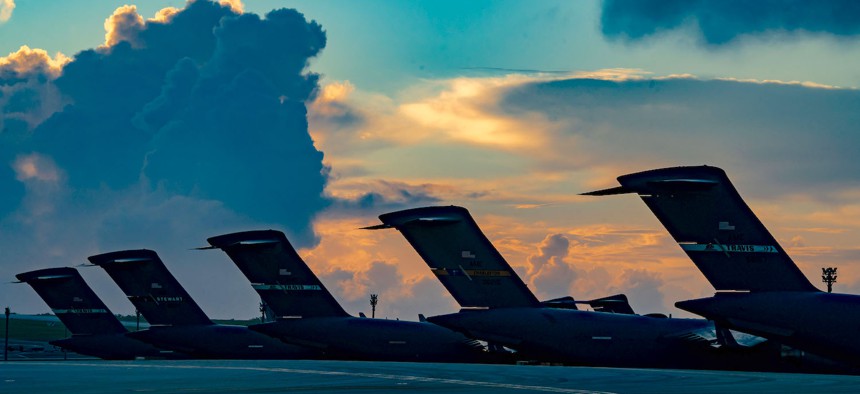 U.S. Air Force C-17 Globemaster IIIs rest on the flight line with a coalition partner’s aircraft as the sun rises during Mobility Guardian 23 at Andersen Air Force Base, Guam, July 14, 2023.