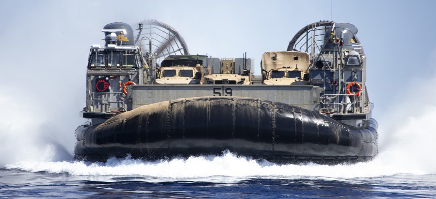 A Navy Marine Expeditionary Ship Interdiction System launcher, a command and control vehicle and a Joint Light Tactical Vehicle are transported by a U.S. Navy Landing Craft Air Cushion from Pacific Missile Range Facility Barking Sands, Hawaii, out to USS San Diego for Large Scale Exercise 2021 on Aug. 16, 2021.