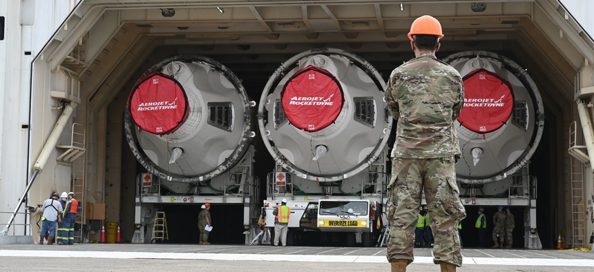 An airman watches as three Delta IV rocket boosters arrive at Vandenberg Space Force Base, California, on August 23, 2021.