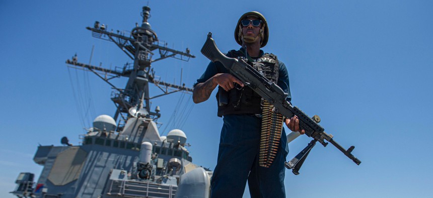 Master-at-Arms 1st Class Julius Earl stands watch with an M240B machine gun aboard guided-missile destroyer USS Paul Hamilton (DDG 60), May 8, 2023, while transiting the Strait of Hormuz. 
