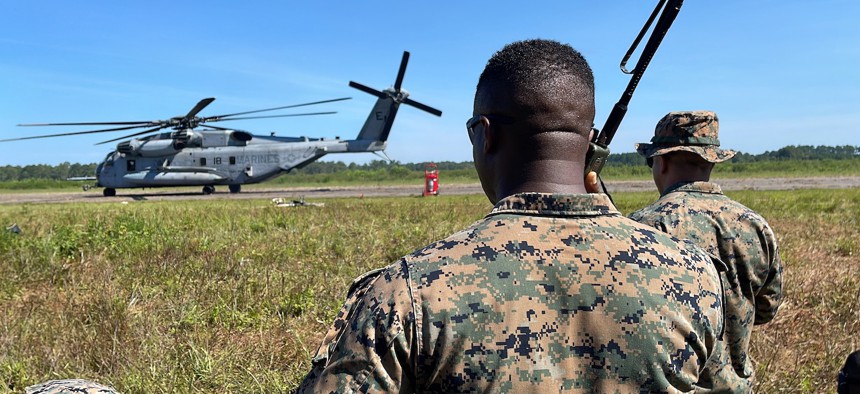A member of a Marine Air Traffic Control Mobile Team, or MMT, watches a CH-53E helicopter make its way down a landing strip near Marine Corps Air Station Cherry Point, N.C., to be refueled during Large Scale Exercise 23 on Aug. 11, 2023. 