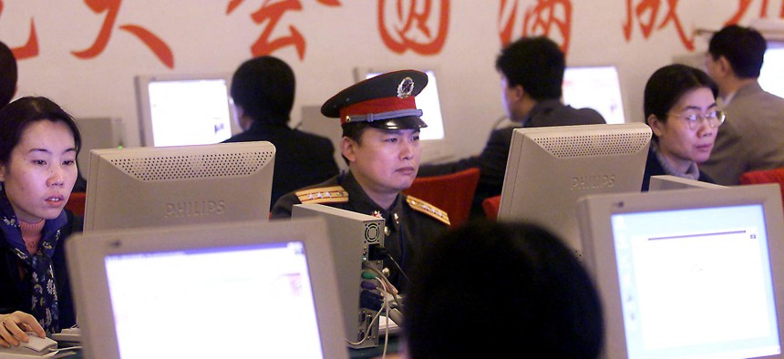 A Chinese military delegate, along with other delegates, checks out information on delegates, issues and schedules on an intranet circuit in the Great Hall of the People during the second session of the National People's Congress 06 March 2001.