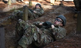 Army infantry recruits crawl under barbed wire as part of the confidence course on Fort Benning, Georgia, March 29, 2023.