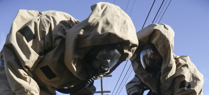 U.S. Marines assigned to Chemical, Biological, Radiological and Nuclear (CBRN) Defense, I Marine Expeditionary Force fill sand bags while dressed in Mission-Oriented Protective Posture (MOPP) level IV, during a CBRN Defense challenge on Marine Corps Air Station Miramar, San Diego, Calif., April 30, 2015