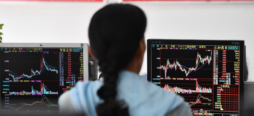 An investor is paying attention to the changes in the Shanghai Composite Index displayed on a computer screen at the Hua'an Securities Trading Office in Fuyang City