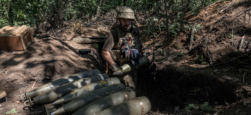 A Ukrainian soldier carries the 155mm shells for M777 artillery at their artillery position in Donetsk Oblast, Ukraine on August 6, 2023.