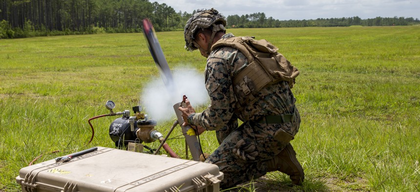Marine Corps Lance Cpl. Isiah Enriquez launches a Switchblade drone during a training exercise at Camp Lejeune, N.C., on July 7, 2021.