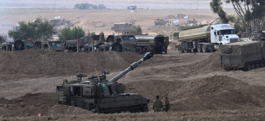 Israeli troops and artillery gather on the border with the Gaza Strip on October 12, 2023, near Sderot, Israel. 