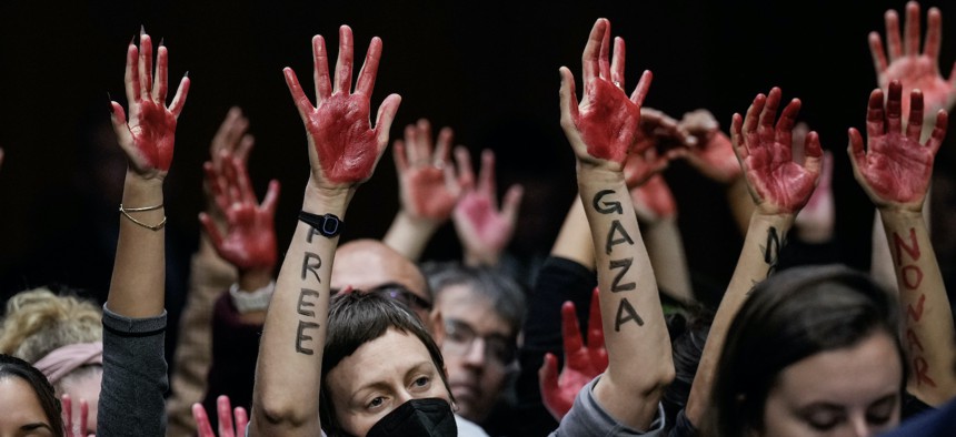 Protestors calling for a ceasefire in Gaza raise their hands, painted in red, during a Senate Appropriations Committee hearing with U.S. Secretary of State Antony Blinken and U.S. Secretary of Defense Lloyd Austin on October 31, 2023.