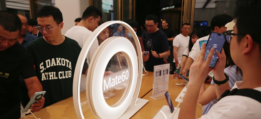 Customers check out Mate 60 smartphones at Huawei's flagship store in Shanghai, China, September 24, 2023. 