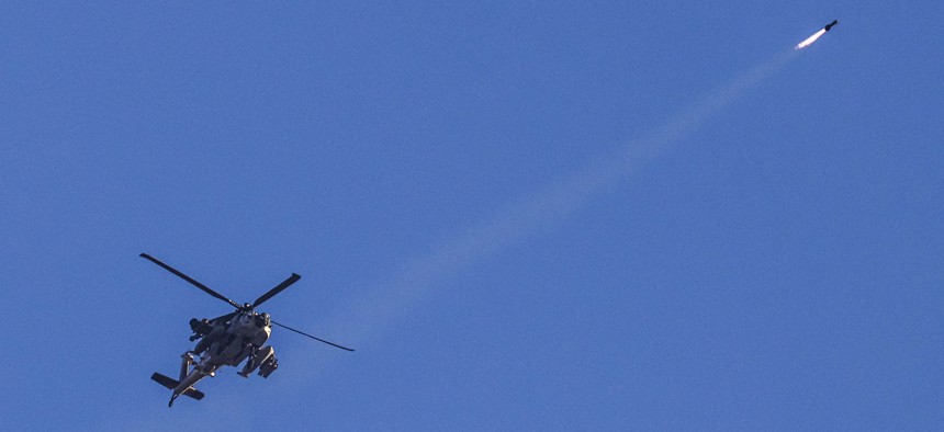 An Israeli Air Force attack helicopter fires a missile while flying over the border with the Gaza Strip near southern Israel on November 8, 2023.