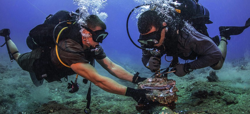 Divers with the U.S. Navy's Underwater Construction Team 2 remove corroded zinc anodes from an undersea cable at the Pacific Missile Range Facility Barking Sands, Hawaii, on July 5, 2016.