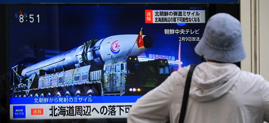 A woman watches street TV broadcasting breaking news of a North Korean missile launch in Tokyo on April 13, 2023.