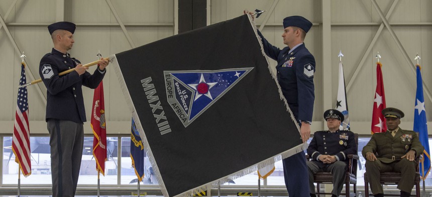 U.S. Space Force Senior Master Sgt. Travis Demarest, U.S. Space Forces Europe & Africa senior enlisted leader, and Tech. Sgt. Saric Barcello, ceremony proffer, unfurl the USSPACEFOR-EURAF flag at Ramstein Air Base, Germany, Dec. 8, 2023. 