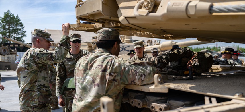 Maj. Gen. David Doyle, commanding general of the 4th Infantry Division, is briefed on M1A2 Abrams operations by armor officer 1st Lt. Eoin Hart during a visitation near Pabrade, Lithuania, on June 23, 2023.