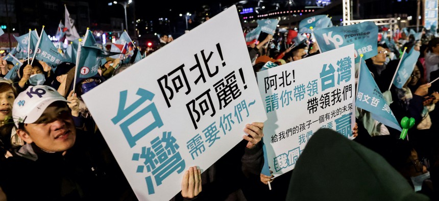 Supporters hold signs saying 'Taiwan needs you, give our children a bright future' at an election campaign rally of Taiwan People's Party (TPP) in Keelung on January 10, 2024.