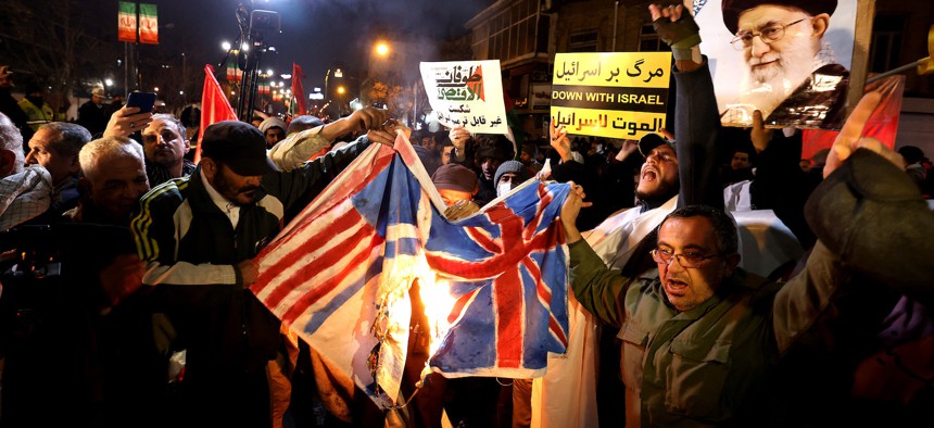 Iranian protesters burn a Union Jack flag and a U.S. flag during a demonstration in solidarity with the Palestinian people and Iran-backed Houthi rebels following US and British forces strikes on Houthi-controlled locations in Yemen, in front of the British embassy in Tehran on January 12, 2024
