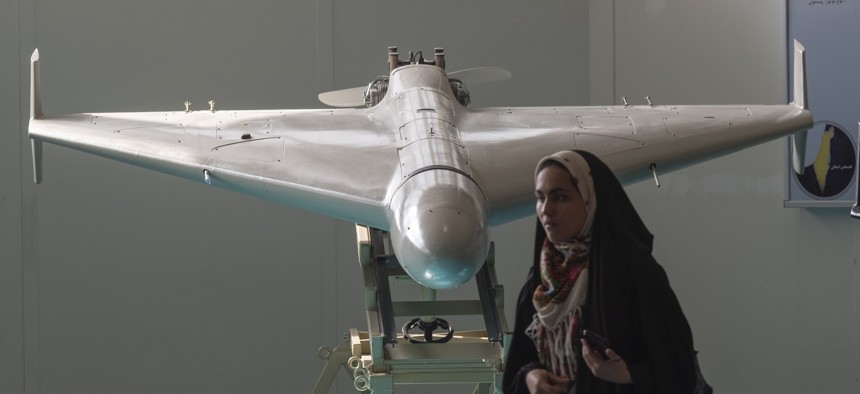 A veiled Iranian schoolgirl stands in front of Iran's Shahed-136 unmanned aerial vehicle while visiting of Iran's Islamic Revolutionary Guard Corps (IRGC) National Aerospace Park in western Tehran, October 11, 2023. 