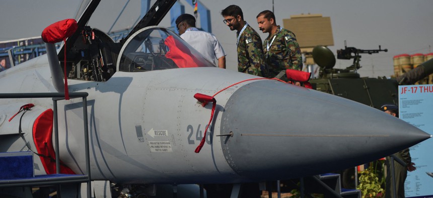 Military officials look at an Pakistan's JF-17 Thunder aircraft during International Defence Exhibition and Seminar (IDEAS) 2022 at the Expo Centre in Karachi on November 16, 2022.