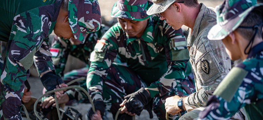 Two U.S. Army soldiers assist Indonesian service members during Exercise Super Garuda Shield in Indonesia, September 1, 2023.