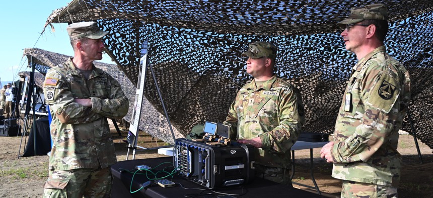 Maj. Gen. Curtis A. Buzzard, commander of Fort Moore and the U.S. Army Maneuver Center of Excellence, speaks with demonstrators from Army Futures Command about modern power consumption demands during Project Convergence Capstone 4, March 5, 2024.