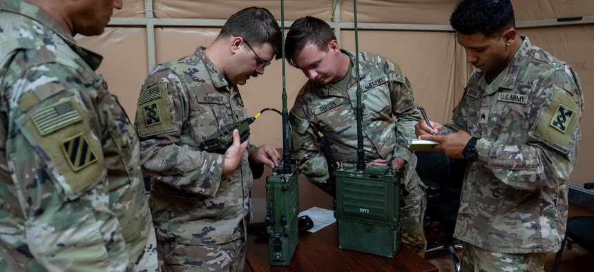U.S. Army signal support operations specialists assess their proficiency using a multiband networking manpack radio at Camp Arifjan, Kuwait, June 9, 2023.