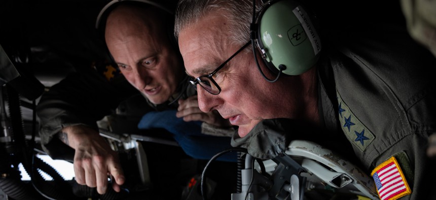 Gen. Mike Minihan, Air Mobility Command commander, listens to 108th Air Refueling Squadron boom operator Technical Sgt. Ryan Mullins give instruction on how to operate the boom of a KC-135 Stratotanker during an orientation flight, March 2, 2024. 