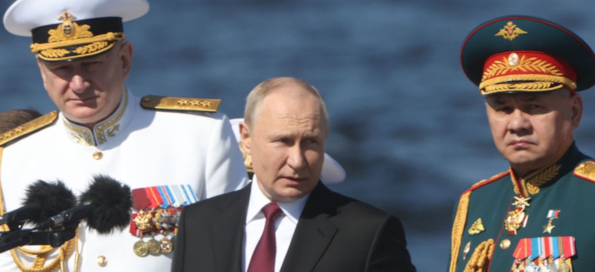 Russian President Vladimir Putin (C), Defence Minister Sergey Shoigu (R) and Navy Commander-in-Chief Nikolai Yevmenov (L) sail on a boat during the annual Navy Day Parade on July 30, 2023, in Saint Petersburg, Russia.