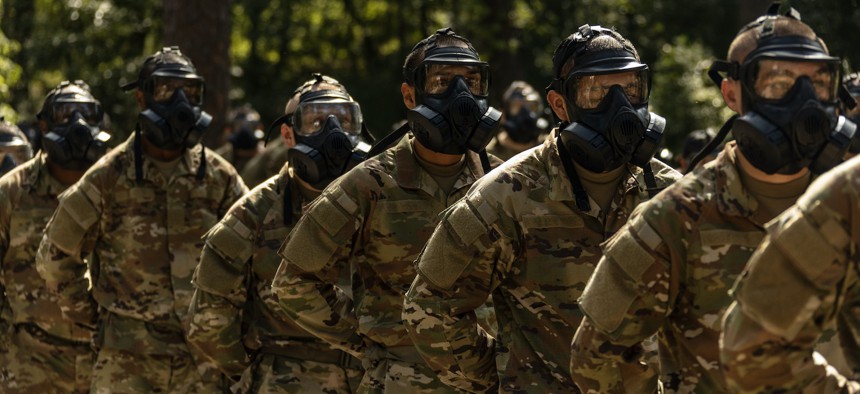 In this 2023 photo, Army recruits line up in gas masks during basic training at Fort Jackson, S.C. 