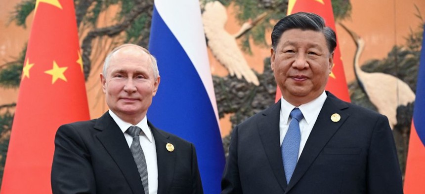 Russia's President Vladimir Putin and Chinese President Xi Jinping shake hands in Beijing on October 18, 2023.