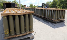 An ammo handler at Blue Grass Army Depot in Kentucky prepares 155mm projectile rounds for repalletization in 2022.