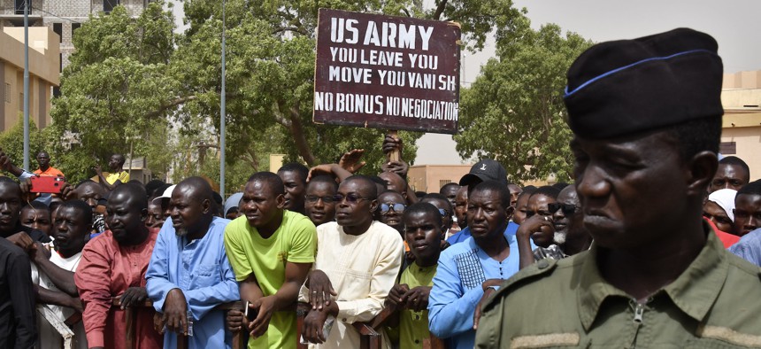 Protesters gather as a man holds up a sign demanding that soldiers from the United States leave Niger without negotiation during a demonstration in Niamey, on April 13, 2024.