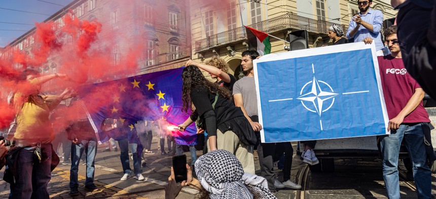 Pro-Palestinian protesters burn the flags of the European Community and NATO, in Turin, Italy, on May 18, 2024.