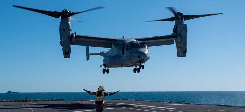 In this 2023 photo, a Royal Australian Navy sailor guides a U.S. Marine Corps MV-22B Osprey tiltrotor aircraft onto the Royal Australian Navy ship HMAS Adelaide (L01) during Exercise Southern Jackaroo 23, off the coast of Queensland, Australia.