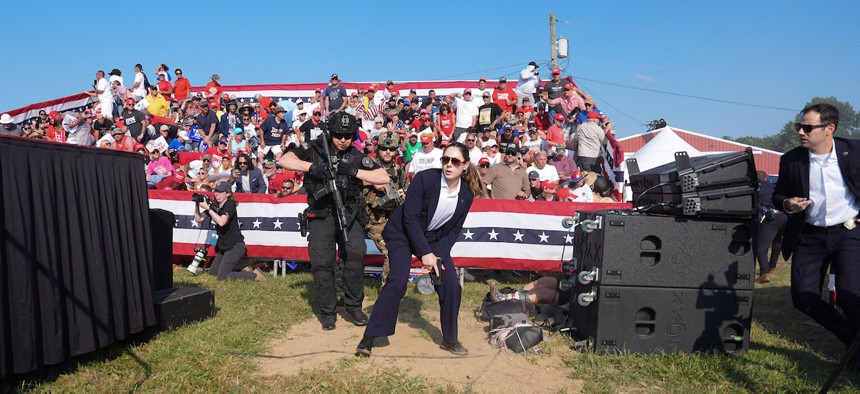 Secret Service agents approach the stage during a campaign rally for former President Donald Trump in Pennsylvania on July 13. Trump ducked and was taken offstage after loud noises were heard after he began speaking. 