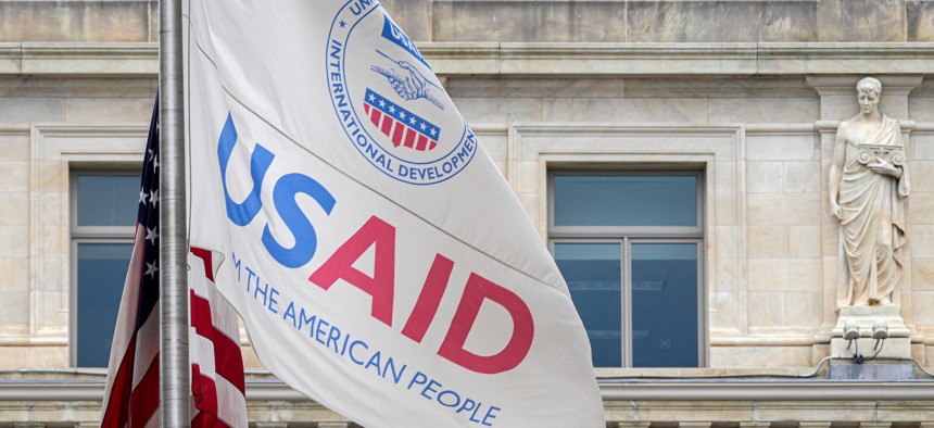 Flags fly outside USAID's headquarters in Washington, D.C. The agency is contracting with IBM to supply cybersecurity support services for U.S. allies.