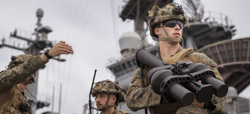 U.S. Marine Corps Cpl. Nikolaus Tinsley, right, a machine gunner assigned to Battalion Landing Team 1/5, 15th Marine Expeditionary Unit, and native of California, scans the area for simulated threats with a NightFighter S portable counter-unmanned aerial vehicle system during training aboard the amphibious assault ship USS Boxer (LHD 4) in the Pacific Ocean July 20, 2024. 