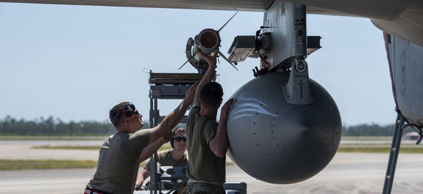 Airmen load an AIM-120 advanced medium-range, air-to-air missile onto an F-15C Eagle during Checkered Flag 22-2 at Tyndall Air Force Base, Fla., May 12, 2022.