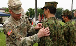 Maj. Gen. JB Vowell, left, commander of U.S. Army Japan, places a new patch on a Japan Ground Self-Defense Force member during a ceremony at Camp Zama, Japan, June 17, 2022.