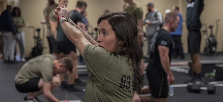 Christi Swain, 93d Air Ground Operations Wing strength coach, demonstrates workout technique during Tactical Performance Training Model physical training at the Human Performance Optimization Summit on Feb. 14, 2024, at Moody Air Force Base, Georgia.