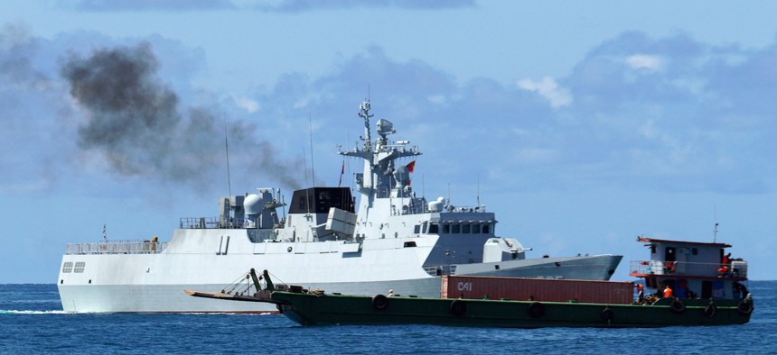 A Chinese warship sails next to a boat representing a hijacked vessel for the China-Cambodia Dragon Gold 2024 maritime exercises off the coast of Cambodia's Preah Sihanouk province on May 24, 2024.