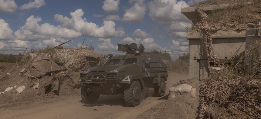 Ukrainian troops drive an armored military vehicle past a destroyed border-crossing point with Russia, in the Sumy region, on August 14, 2024.