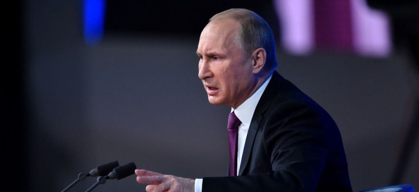 Russian President Vladimir Putin gestures as he speaks during his annual press conference in Moscow on December 18, 2014.