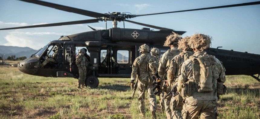 Soldiers assigned to the 1st Stryker Brigade Combat Team, 4th Infantry Division, along with soldiers from the 10th Special Forces Group, walk towards a UH-60 Blackhawk helicopter during an air assault to perform special reconnaissance operations in conjunction with IVY MASS at Fort Carson, Colorado, on June 6, 2024.