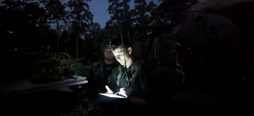 U.S. Army Sgt. Michael Corely, a team leader in the "Ghost" reconnaissance unit, checks a tablet during a recent exercise at Fort Johnson, Louisiana.