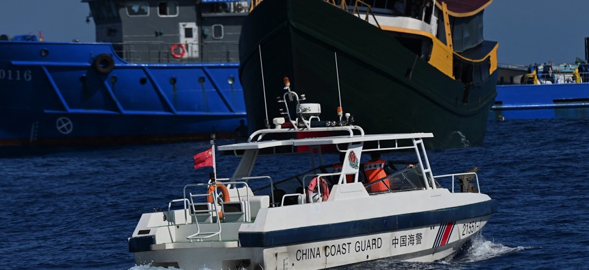 This photo taken on March 5, 2024, shows a China Coast Guard patrol boat (front) sailing near the Philippine military chartered Unaizah May 4 (C) during its supply mission to Second Thomas Shoal in the disputed South China Sea