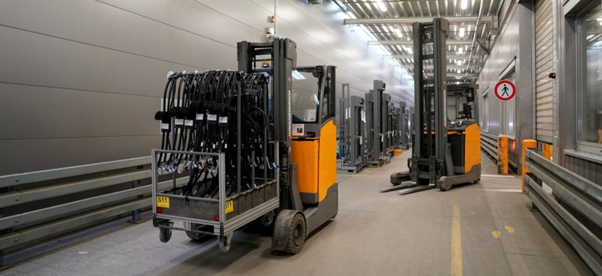 24 April 2024, Schleswig-Holstein, Norderstedt: Forklift trucks drive through the factory hall of Jungheinrich AG. Jungheinrich is a manufacturer of forklift trucks and pallet trucks.