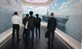 Visitors watch a video loop at the RTX exhibition stand at the Farnborough International Airshow on July 22, 2024, at Farnborough, England. 