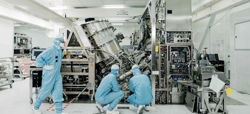 Technicians work on an ASML semiconductor lithography tool, a key advantage in US and its allies' chip race with China.