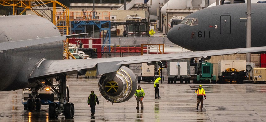 Workers stand near KC-46A Pegasus aerial refueling jets at Boeing's airplane production facility in Everett, Washington, in 2021.